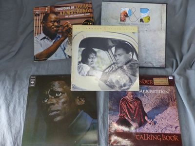a lot of music books on a bed with a blue blanket
