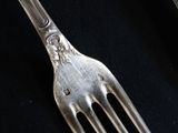a fork and a spoon sitting on a black cloth