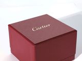 une boîte rouge ornée d'une inscription dorée, posée sur une surface blanche