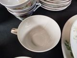 a lot of dishes and cups on the table