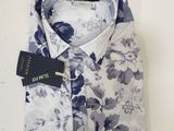 the shirt is blue and white with a floral pattern on it