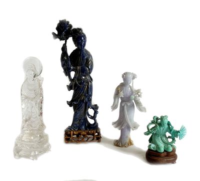 quatre figurines de formes et de tailles différentes posées sur une surface blanche