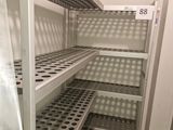 a metal shelf in the middle of a room with lots of shelves
