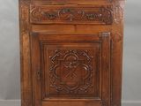 une vieille armoire en bois dont les portes et les tiroirs sont sculptés