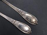 two silver spoons on a black surface with a black background