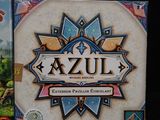 the game box for azzul is next to the box for the card game