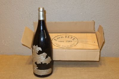 une bouteille de vin posée sur une table à côté d'une boîte