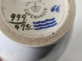 a close up of a white cup with blue writing on it