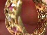 a close up of a gold ring with pink stones in it
