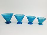 three blue glass vases sitting next to each other on a white surface