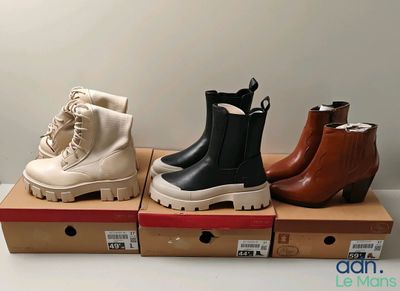 Trois paires de bottes pour femmes sont exposées dans une boîte