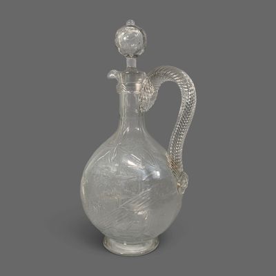 a glass bottle with a snake handle on a gray background