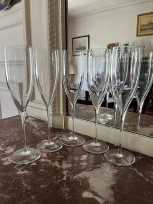 several empty wine glasses are lined up on a marble counter