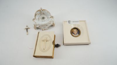 une petite boîte ornée d'une image, posée à côté d'un bougeoir et d'un chapelet