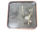a black tray with flowers and leaves on it