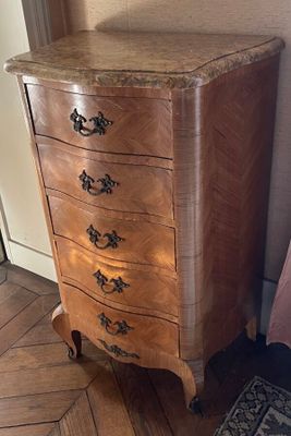 a small chest of drawers in the corner of a room