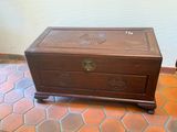 a small wooden chest sitting on a tiled floor