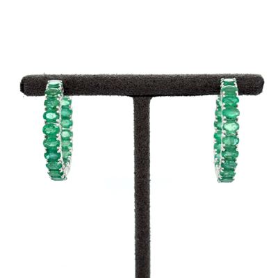 a close up of a pair of green earrings on a stand