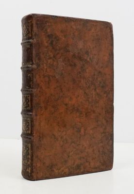 an old book sitting on top of a table next to a white wall