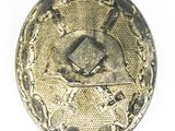 a silver button with a picture of a man on it