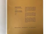 an open book on a white surface with a gold cover