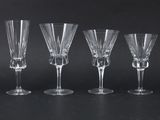 four wine glasses are lined up on a black surface