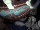 a brown and blue vase sitting on a blue table