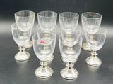 six clear wine glasses sitting on top of a table next to each other