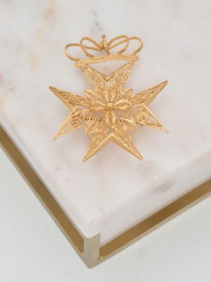 décoration en forme d'étoile plaquée or sur un socle en marbre blanc