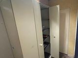 a closet in the corner of a room with a lot of clutter on the floor