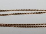 a gold chain with a clasp on it on a white surface