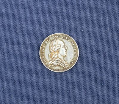 un gros plan d'une pièce de monnaie posée sur un tissu bleu