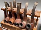 a lot of pipes that are on a wooden stand