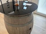 a table made out of a wine barrel with a bottle on top