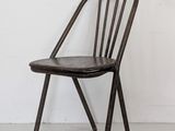 a chair that is leaning against a white wall