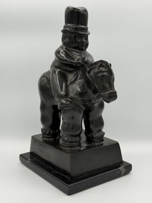 statue of a man riding a horse with a hat on his head