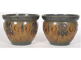 deux vases posés l'un à côté de l'autre sur une surface blanche