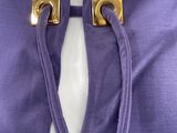 purple dress with gold buttons and a tie around the neck