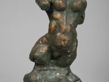 l'image d'une statue de bronze représentant une femme assise sur un rocher