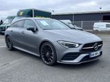 a grey mercedes cla parked in a parking lot next to a truck