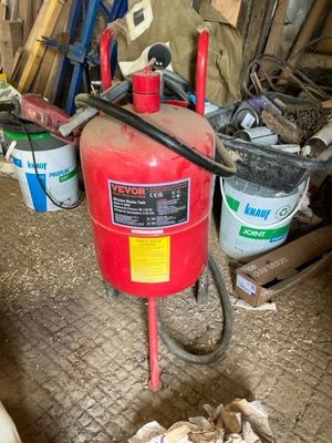 a red fire extinguisor sitting on the floor in a garage