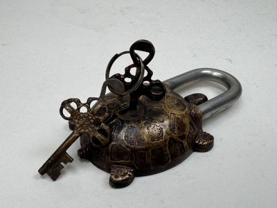 a key on top of a turtle shaped key holder