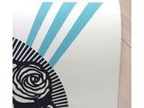 a close up of a white and blue poster on a wooden floor