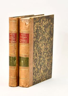 two old books sitting on top of each other on a table