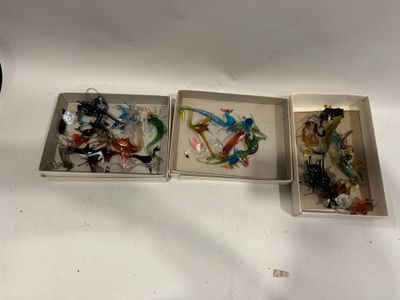 trois boîtes contenant des objets en verre de différentes couleurs