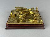 a gold plated sundial on a wooden base on a table