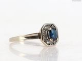 a close up of a ring with a blue stone in it