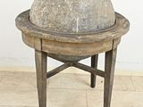 une boule de pierre posée sur un socle en bois