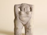 une statue représentant une femme les mains derrière la tête