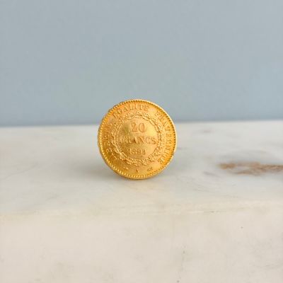 une image représentant une pièce d'or posée sur un comptoir en marbre